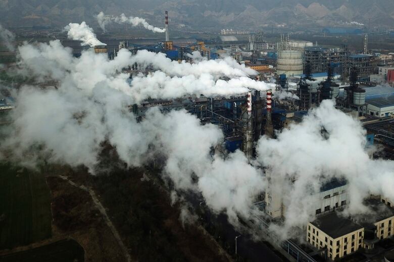 smoke and steam rise from a coal processing plant