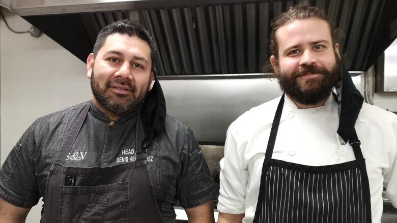 Two men in chef coats in commercial kitchen