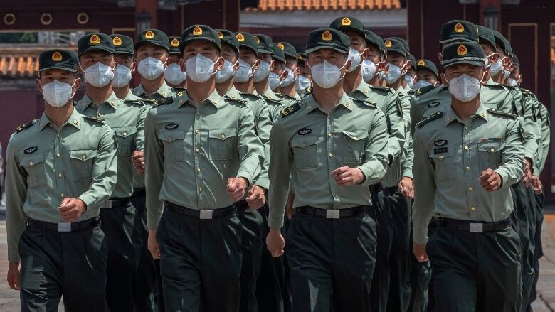 Men in masks marching.