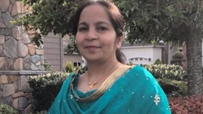 Parmjit Massuta, an Indian woman wearing a teal-coloured sari, is shown in a family photo.