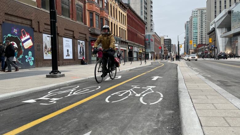 A cyclist makes their way down new bike lanes on Rideau Street in Ottawa.