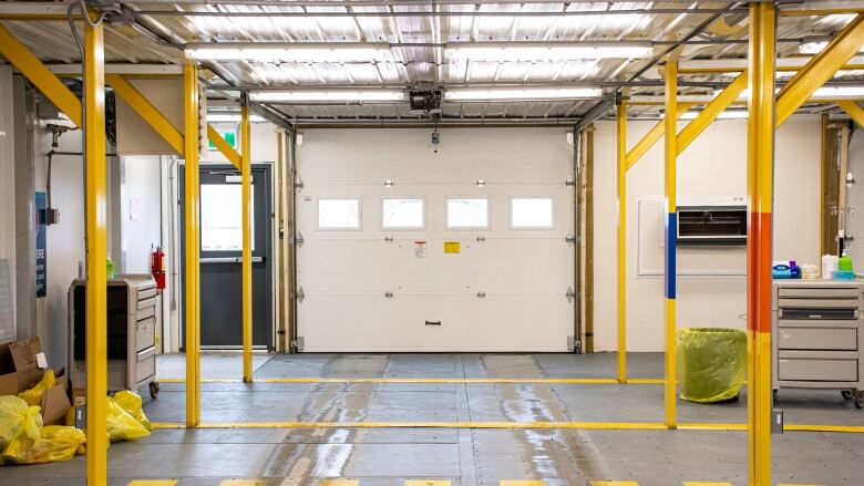 The inside of a well-lit, spacious drive-thru, showing a closed bay door directly ahead.