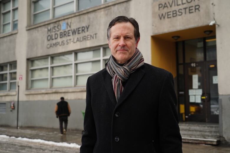 Man in front of building wearing warm jacket