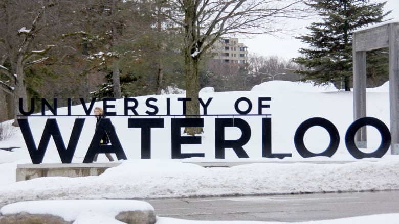 A person walks by the University of Waterloo (UW) sign on campus on Feb. 10, 2020. 