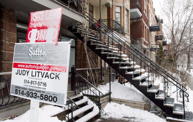 A for sale sign is seen in front of a Montreal home with snow on the sign, on March 17, 2015.