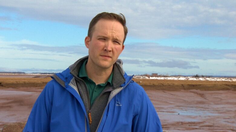 Allan Melvin, president of the Nova Scotia Federation of Labour, looks towards the camera with a neutral expression. He is wearing a blue windbreaker.