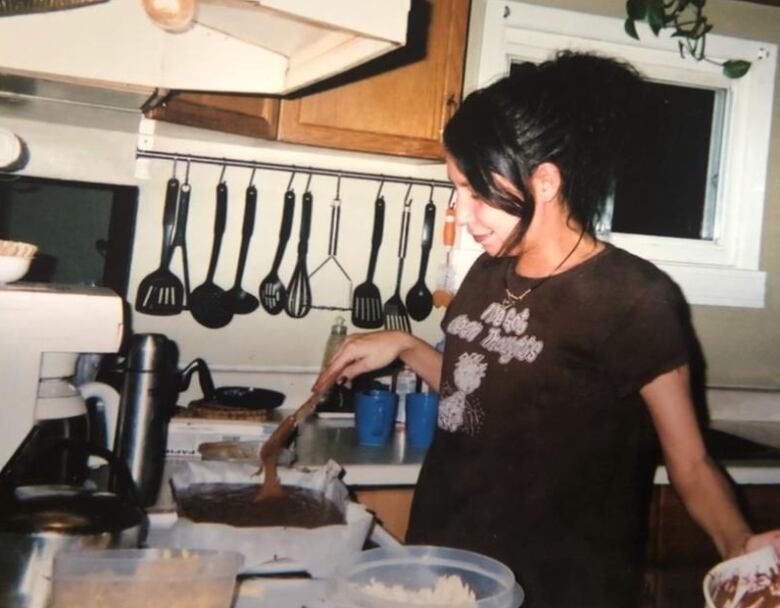 A woman cooking with a frying pan.