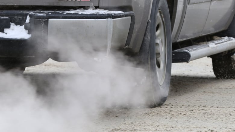 Vapour and smoke flow out of the exhaust pipe of a truck.