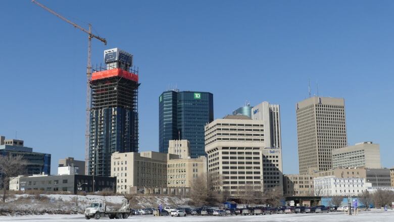 Winnipeg's skyline, with buildings of differing heights. A construction crane works on a new building.