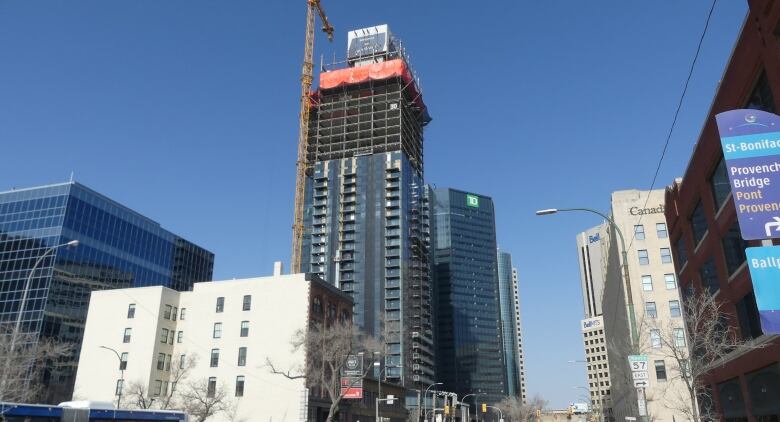 Winnipeg's skyline, with buildings of differing heights. A construction crane works on a new building.