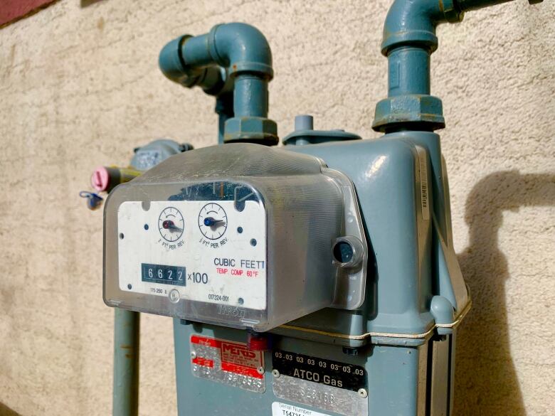 A grey utility meter is shown on the side of a house.