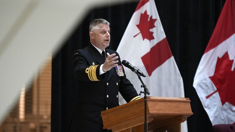 A man in a military uniform gestures while making a speech.