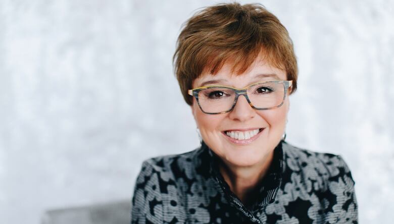 Headshot of woman with short red hair and glasses