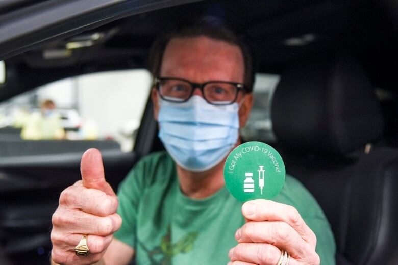 A man in a green shirt and mask.