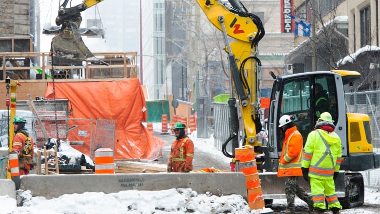 Construction workers work at a downtown site. 