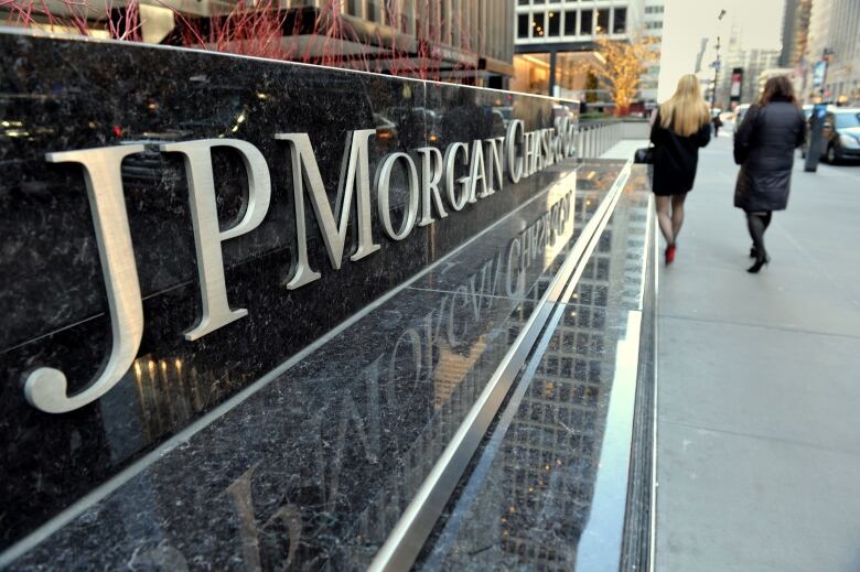 The logo of JP Morgan Chase is shown above a sidewalk on Park Avenue in New York City.