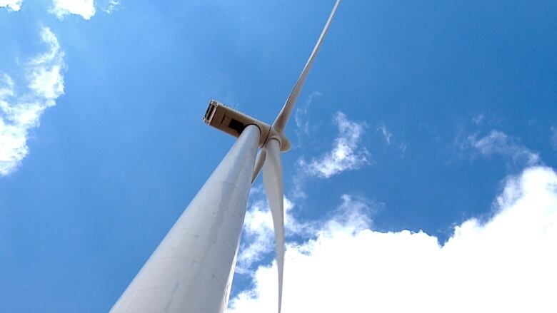 A wind turbine is viewed from the base.