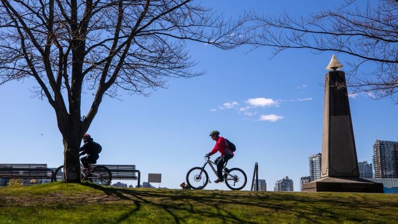 Two cyclists ride along the Stanley Park seawall in Vancouver, B.C.