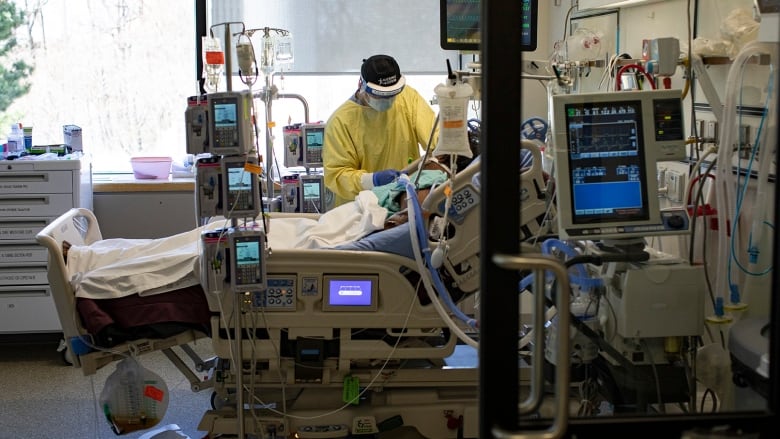 Registered nurse Jose Pasion tends to a patient in the intensive care unit (ICU) at Scarborough Health Networks Centenary Hospital, in north-east Toronto, on April 8, 2021.