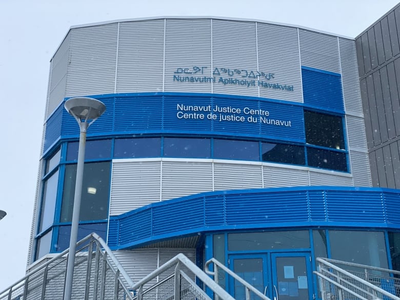 Blue and silver exterior of large building in snow. 