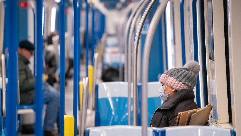 People are sitting in a Metro car. 