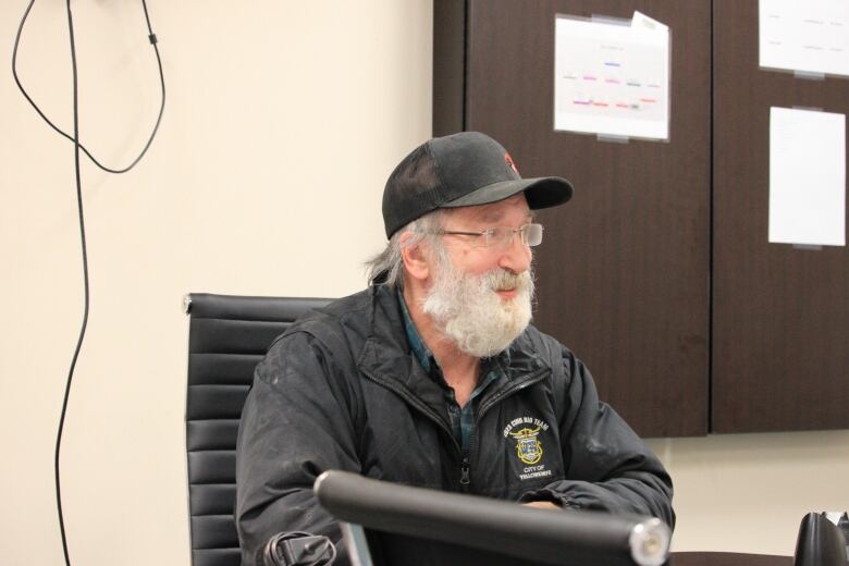 Man wearing a ballcap looking across.