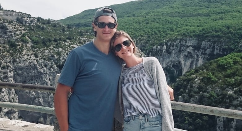 Andrew and Nicole pose for a picture in front of a scenic area. 