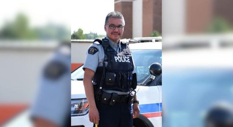 A vertical Image of Bernie Herman in his officer uniform with the borders blurred on both sides