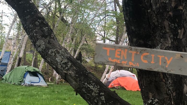 A sign says 'tent city' where an encampment of tents formed in Fredericton.