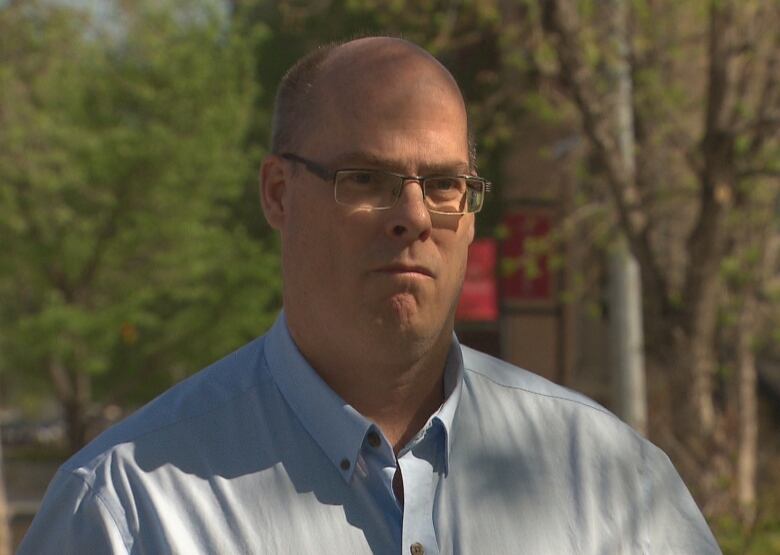 A man wearing a blue button-up shirt.