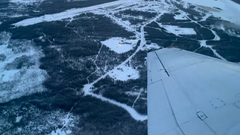 Aerial view of a First Nation, the horizon, wing of a plane.