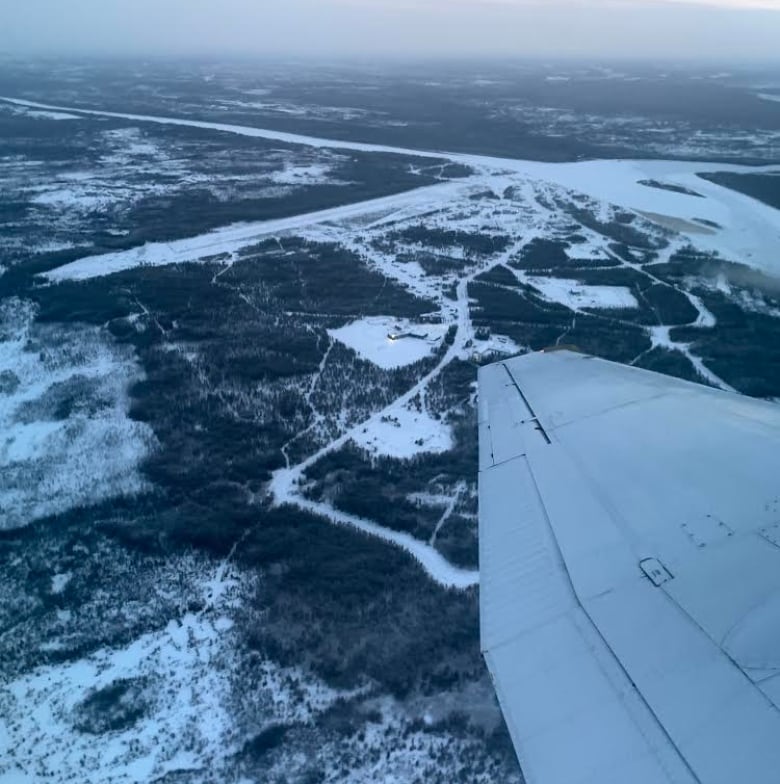 Aerial view of a First Nation, the horizon, wing of a plane.