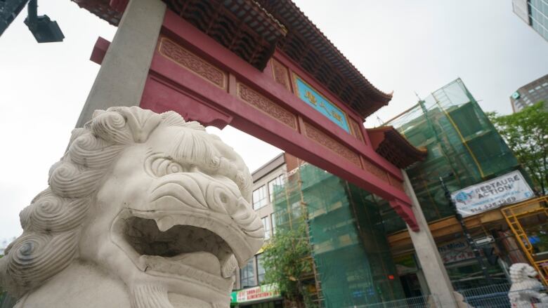 A statue looks on from the gates of Chinatown