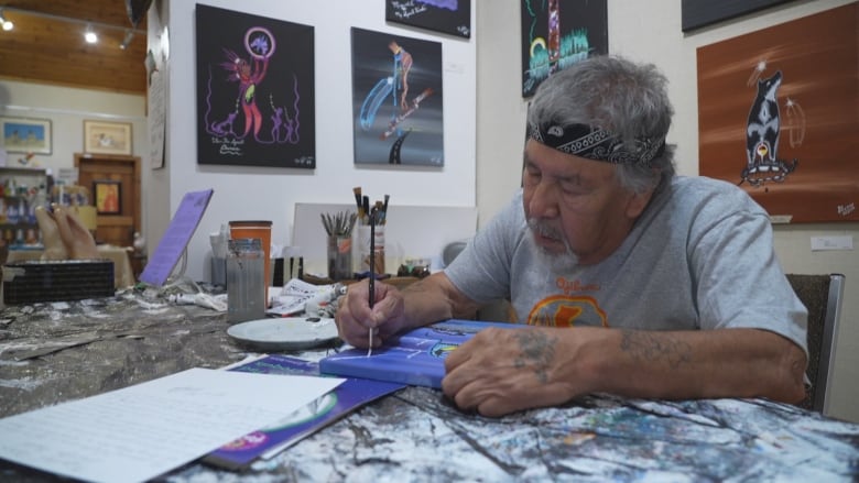 An artist works on a painting in his studio