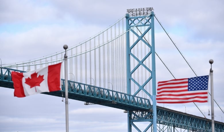 A bridge with a Canadian flag and American flag.