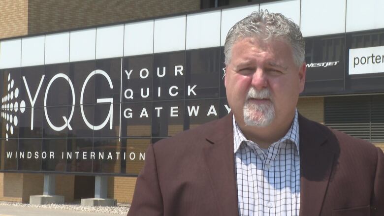 A man standing outside of an airport.