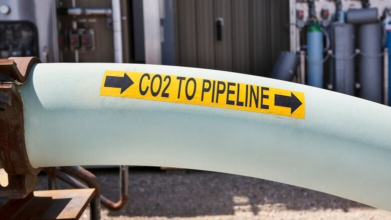 A pipeline with a yellow sign. 