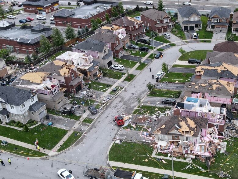 A drone shot shows damaged homes in Barrie, surrounded by debris. 