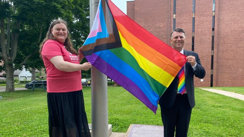 Dennis King raises a Pride flag at provincial buildings with Andrea MacPherson.