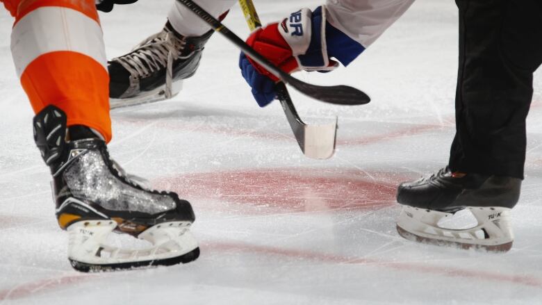 A close up of hockey sticks and skates on the ice.