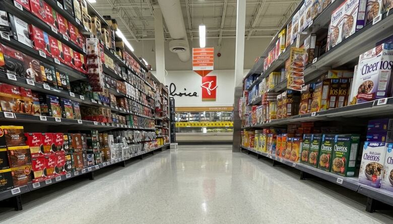 A grocery store aisle with a faded directional arrow on the floor.