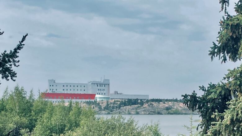 Trees, water, building.