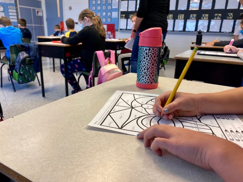 Students in class at Bloomfield Elementary School in PEI showing adaptations for public health protocols. See student at desk in fg working on a math sheet, shot from the side. Taken Aug 11, 2020.