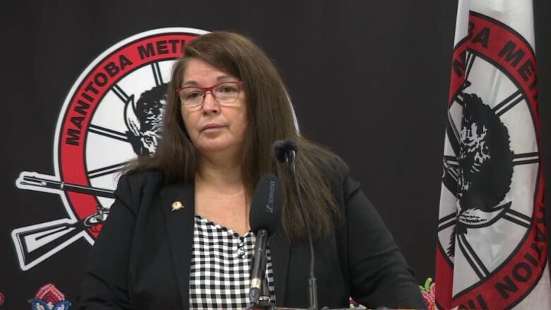 A woman stands at a podium.