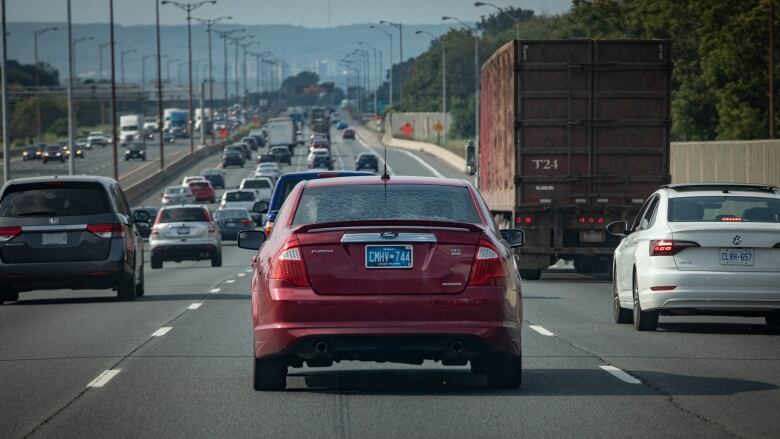 A car with a blue licence plate on the highway.