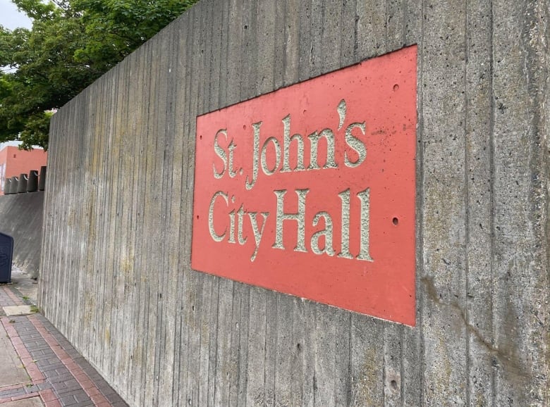 A sign against concrete wall that reads 