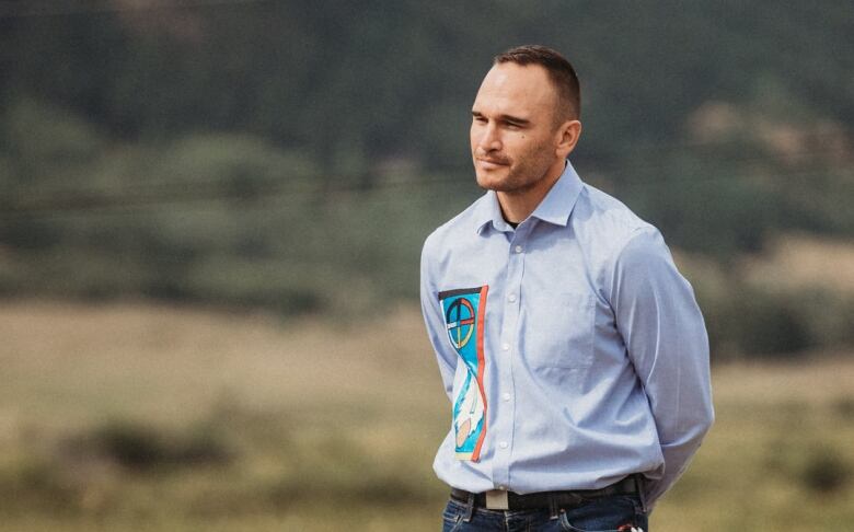 A man stands on grassy ground.