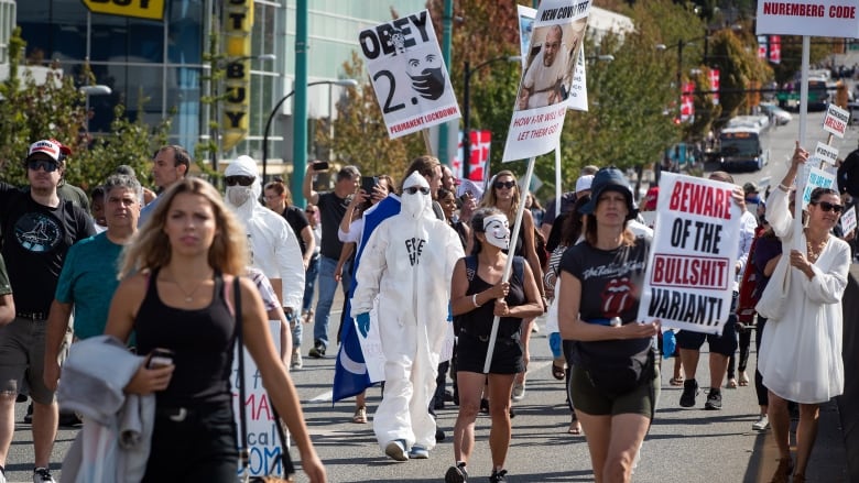 People march during a protest against COVID-19 vaccine passports and mandatory vaccinations for healthcare workers, in Vancouver, on Wednesday, September 1, 2021. The protest began outside Vancouver General Hospital and police estimated the crowd gathered to be as many as 5,000 people.