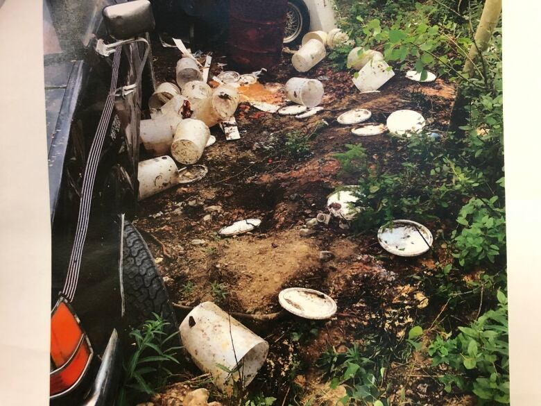 White plastic buckets and lids scattered on the ground. 