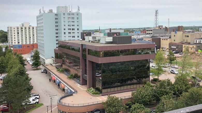 A red brick building with lots of glass windows is shown in an aerial view.